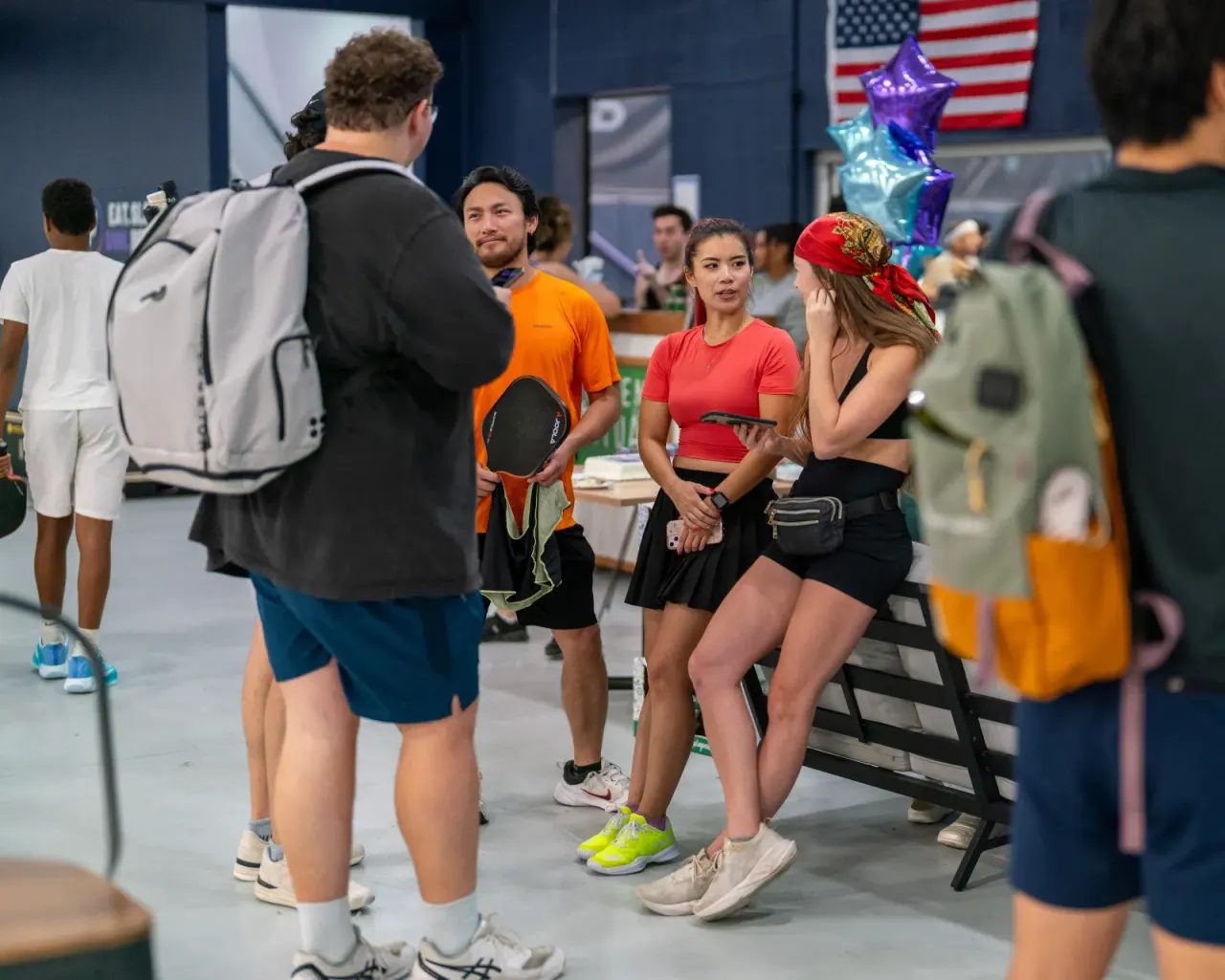 Attendees mingle at event check-in near an American flag