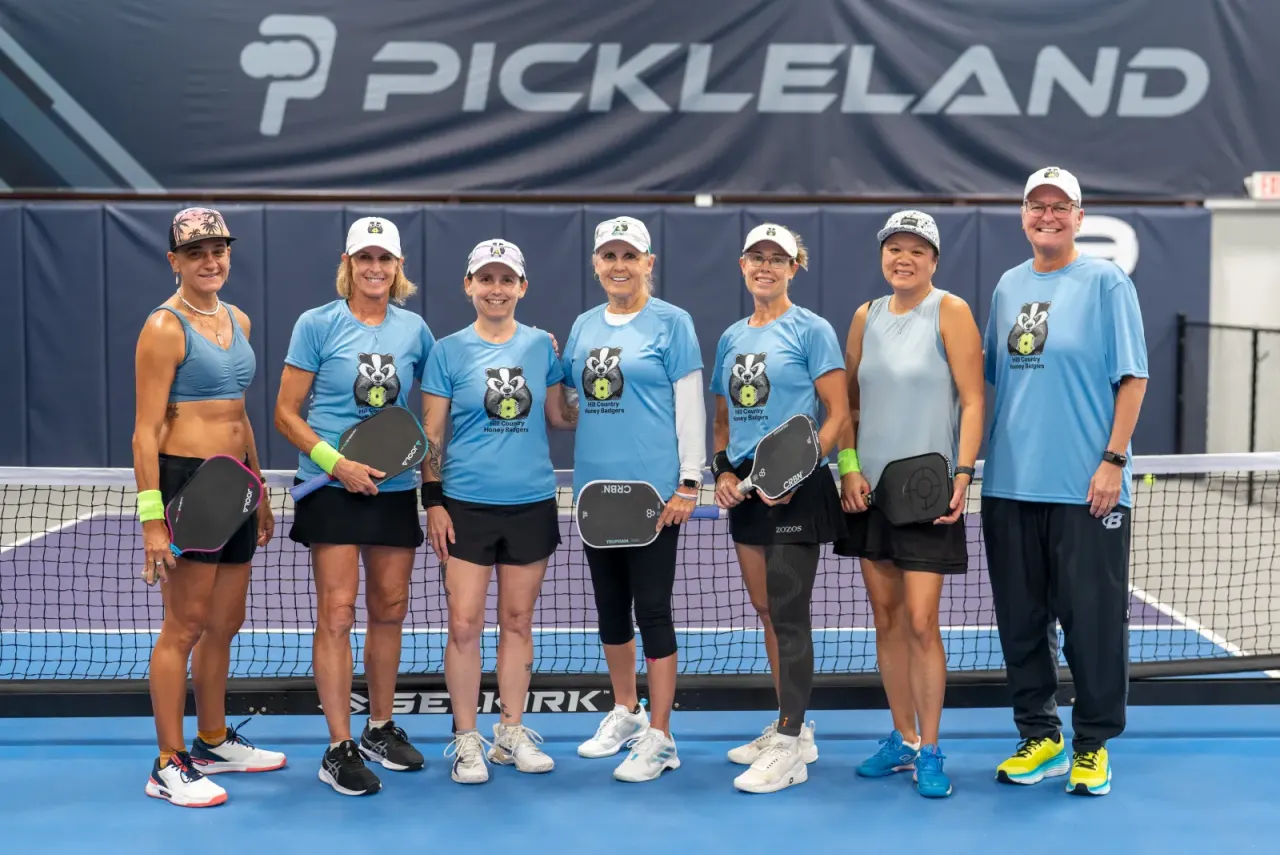 Pickleland league team in matching shirts posing together on the court