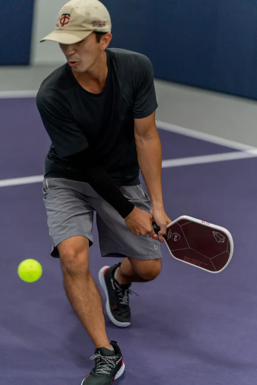 Player gripping a paddle during a dink at Pickleland