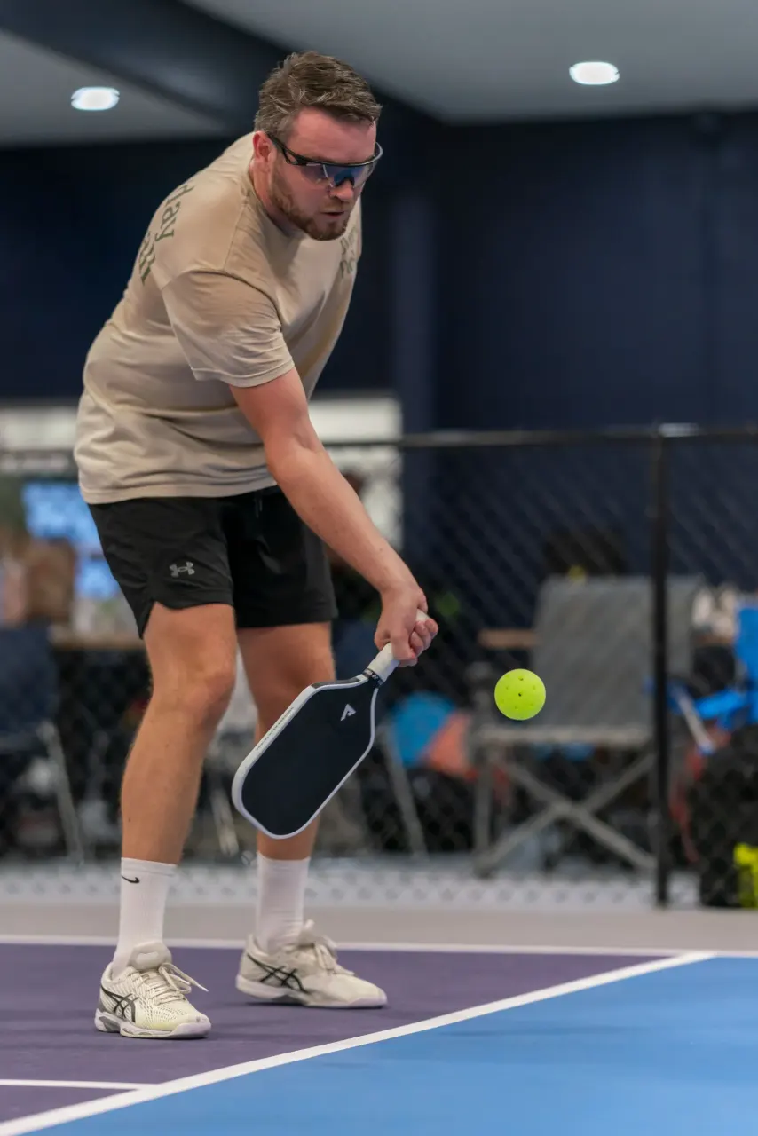 Player striking a forehand with a paddle at Pickleland