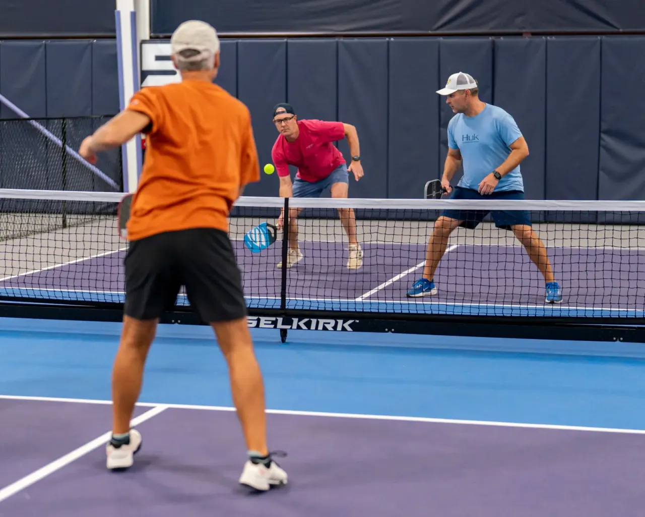 Player serving during a doubles point at Pickleland