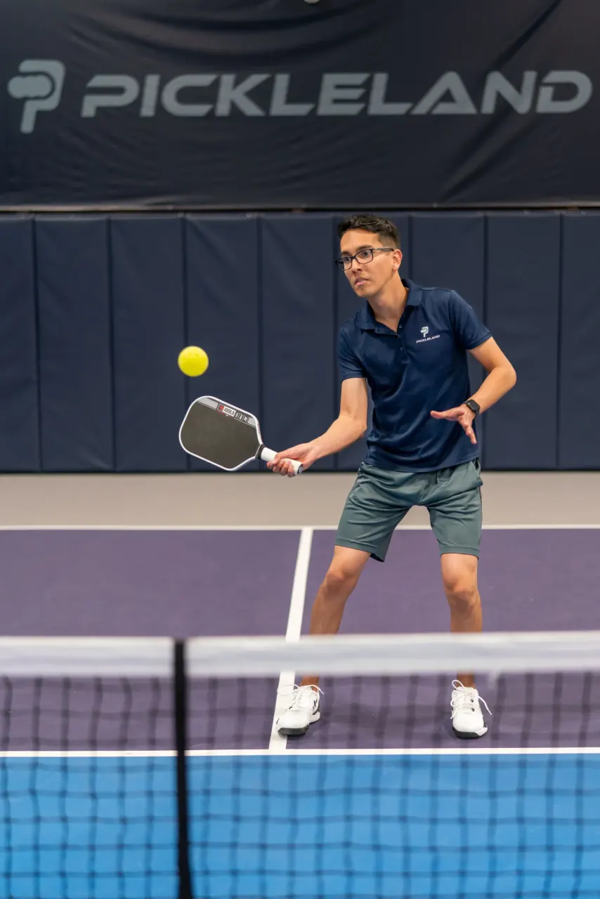Player hitting a backhand at the net at Pickleland
