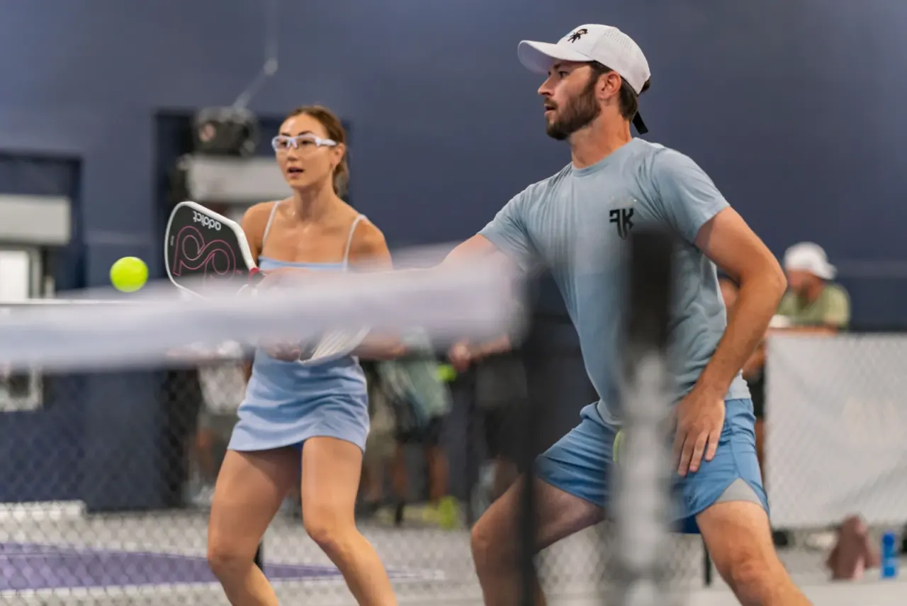 Mixed doubles pair playing at the net