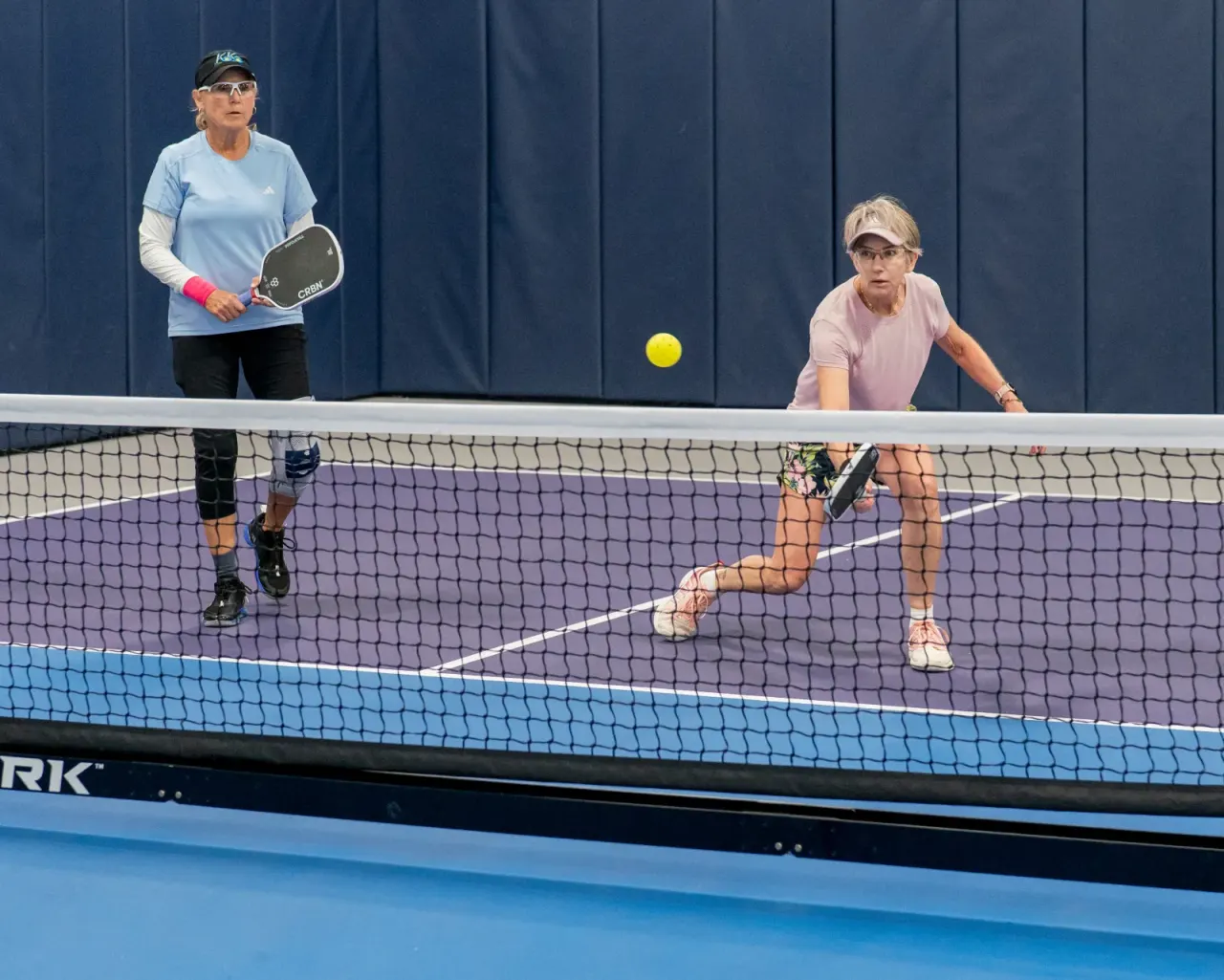 Senior players enjoying a daytime doubles game at Pickleland