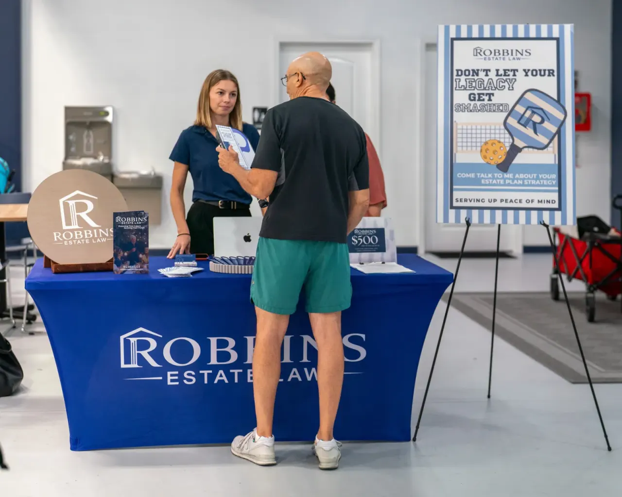 Attendees talking at a sponsor booth during an event expo