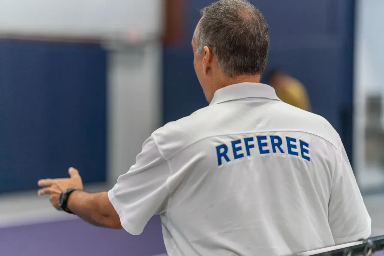Referee officiating a pickleball tournament match at Pickleland