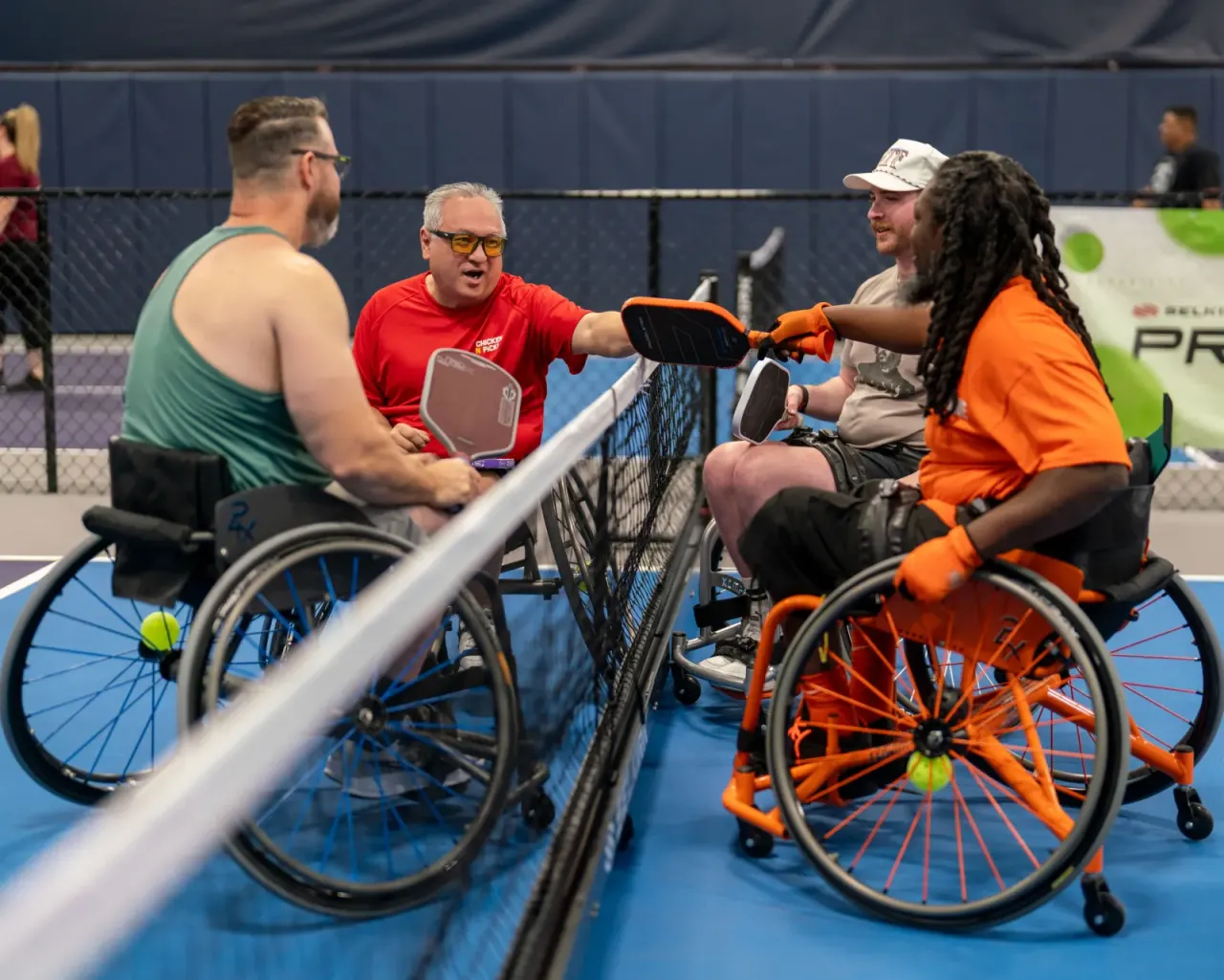 Players enjoying adaptive wheelchair pickleball doubles