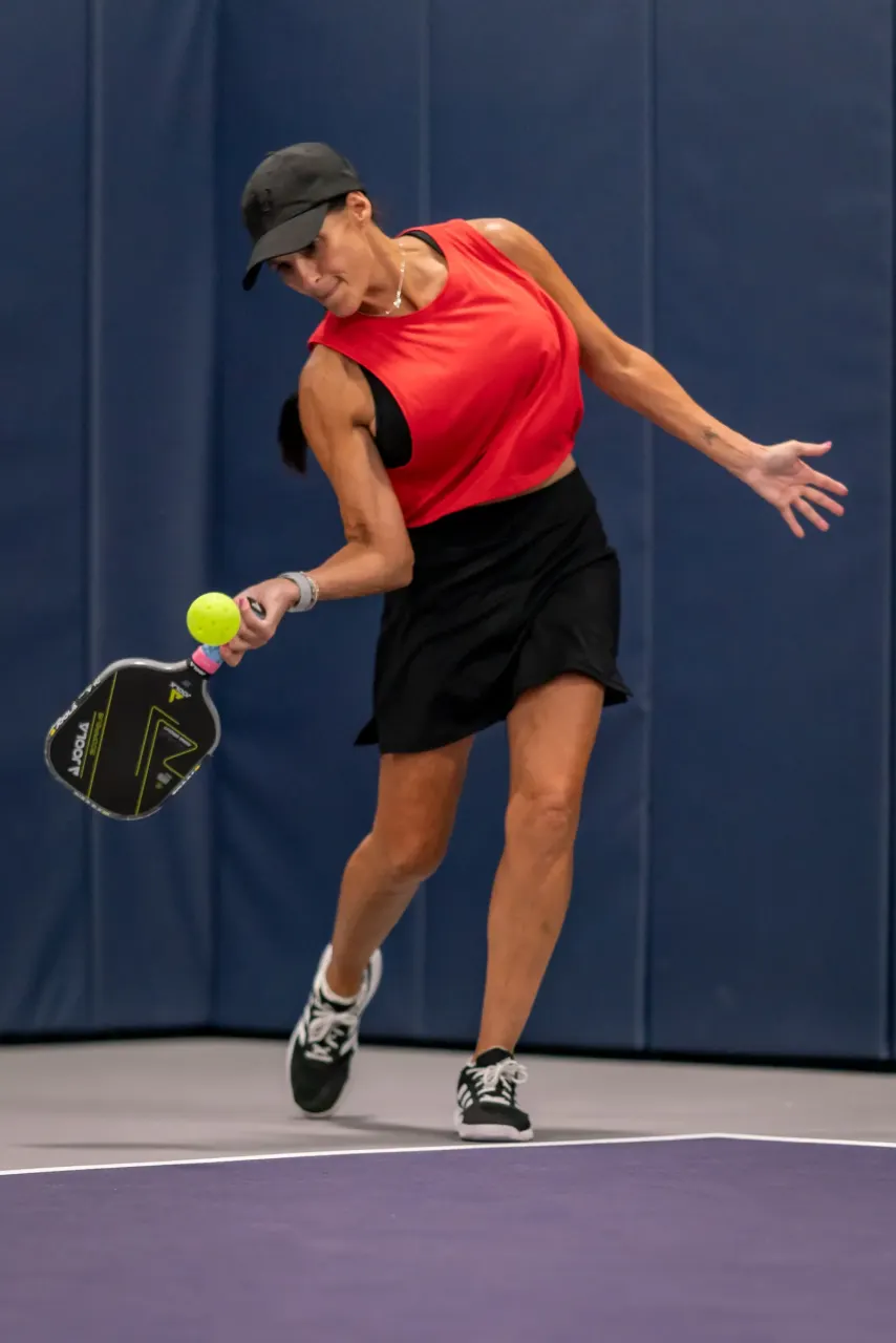 Player striking a serve from the baseline at Pickleland