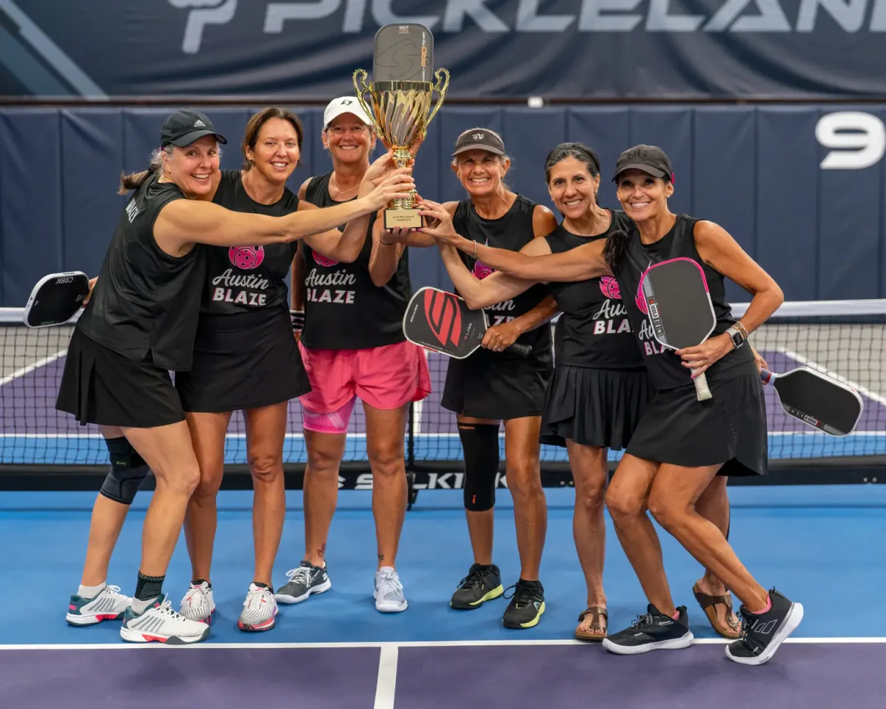 Young women's team celebrates with a fun group pose