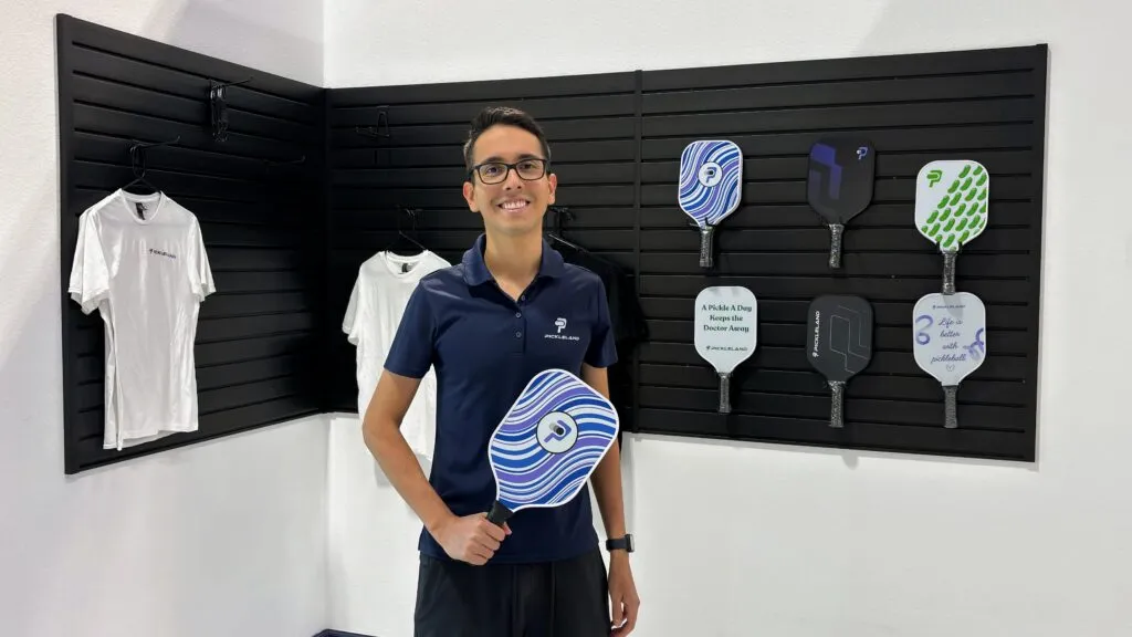 Pickleball paddle and ball resting on the court representing skill rating