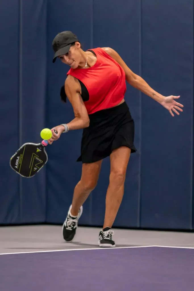 Close-up of a hand holding a pickleball paddle by the grip