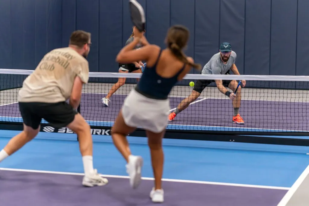 Players rallying on an indoor pickleball court at Pickleland