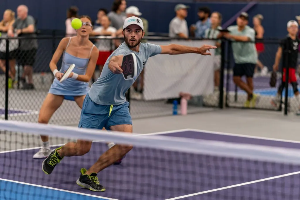 Players enjoying a doubles match on an indoor pickleball court